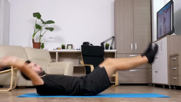 年轻健身男子在家锻炼-他做仰卧起坐 — 图库视频影像