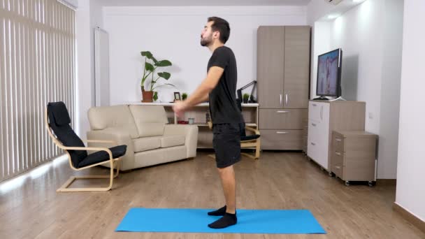 Deporte en casa - hombre atlético haciendo sentadillas en la sala de estar — Vídeos de Stock