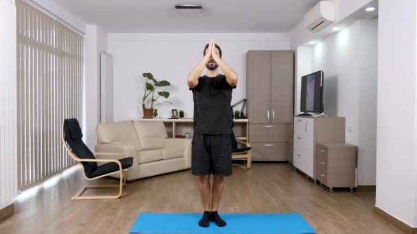 Молодой спортсмен сидит в позе йоги — стоковое видео