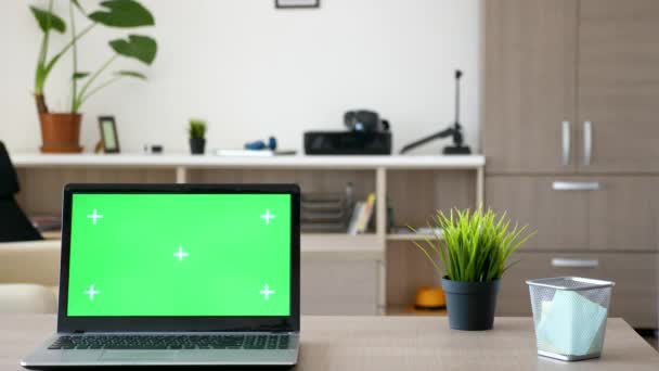 Computador portátil com tela verde zombar em uma mesa no meio da sala de estar — Vídeo de Stock