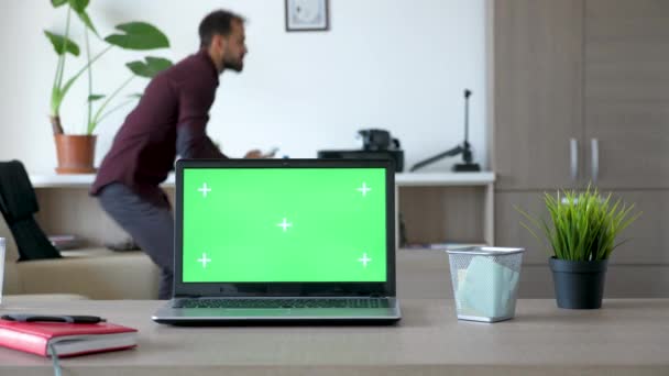 Laptop on the desk with a green screen in the house — Stock Video
