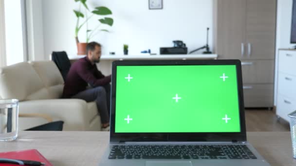 Oturma odasının ortasında yeşil ekran renk üstünde o ile dizüstü bilgisayar — Stok video