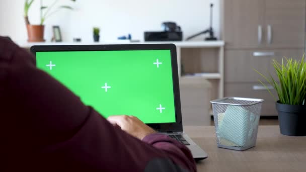 Foto trasera del hombre trabajando en un portátil con pantalla verde en él — Vídeos de Stock