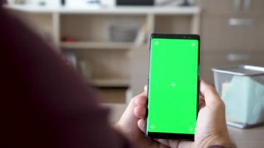 Bir smartphone yeşil ekran renk ile alay etmek yukarıya holding erkek eller görüntüsünü ortaya