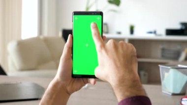Adam el aşağı ve sağ kaydırma yeşil ekran renk ile modern bir akıllı telefon alay kadar