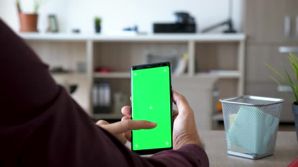 El hombre sostiene un smarpthone con la maqueta verde del croma de la pantalla para arriba — Vídeos de Stock