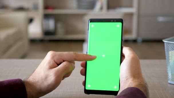 Primer plano del hombre que navega por Internet en el teléfono inteligente con croma pantalla verde maqueta — Vídeos de Stock