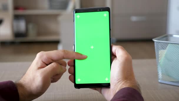 Bir akıllı telefon elinde yeşil ekran renk ile alay etmek yukarıya tutan adam — Stok video