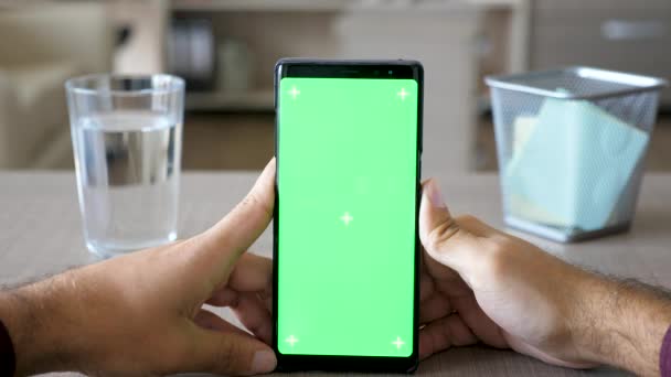 男性の手を保持するクロマ緑色の画面を持つスマート フォン モックアップ — ストック動画