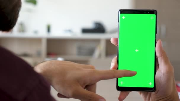 Primer plano de la mano del hombre tocando y utilizando un teléfono inteligente con croma de pantalla verde se burlan de él — Vídeo de stock