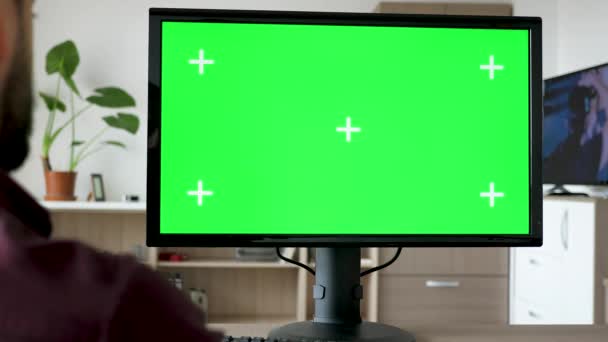 Hombre irreconocible mirando a la computadora personal moderna con croma de pantalla verde grande maqueta — Vídeo de stock