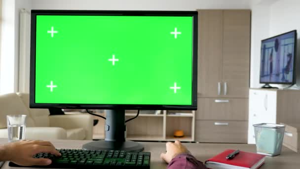 Glidande bilder av första person vy - mannen händerna att skriva på datorns tangentbord med stora greenscreen chroma mock-up — Stockvideo