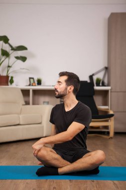 Tiwst yoga pozlar olurken ev yapan erkek