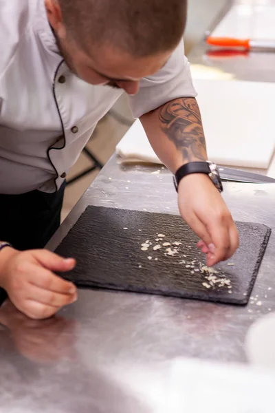 Chef faz design de prato fino na placa preta — Fotografia de Stock