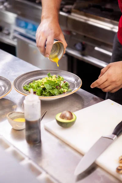 Chef würzt Salat mit Zitronensaft — Stockfoto