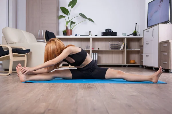 Attactive giovane donna essere flessibile durante la sua formazione a casa — Foto Stock