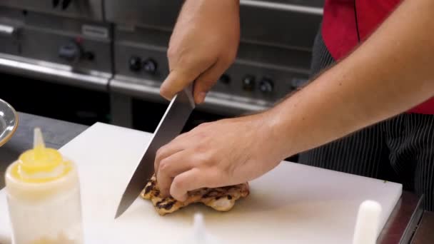 Cocinar las manos cortando un pedazo de carne de pechuga de pollo frito — Vídeos de Stock