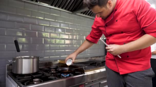 Cocina en la cocina del restaurante preparando un souce — Vídeo de stock