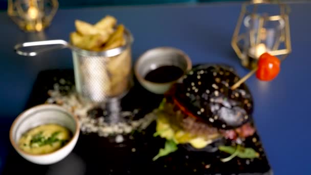 Deliciosa hamburguesa en bollos negros — Vídeos de Stock