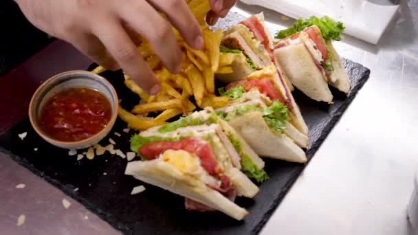 Cocinar las manos colocando papas fritas — Vídeo de stock