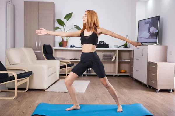 Bella giovane donna che soggiorna in posa Warrior II yoga — Foto Stock