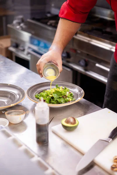 Chef würzt Salat mit Zitronensaft — Stockfoto