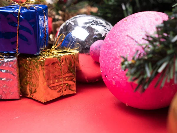 Weihnachtsgeschenkboxen in verschiedenen Farben unter dem Weihnachtsbaum auf rotem Hintergrund — Stockfoto