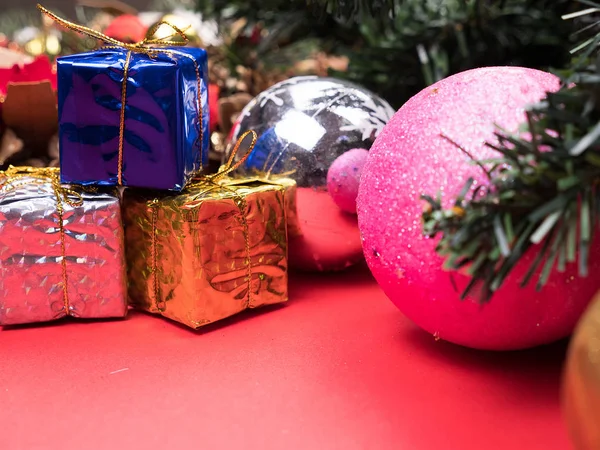 Weihnachtsgeschenkboxen in verschiedenen Farben unter dem Weihnachtsbaum auf rotem Hintergrund — Stockfoto