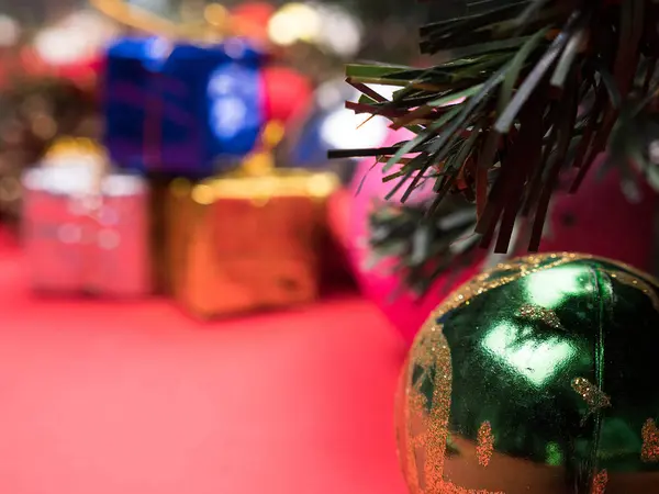 Coffrets cadeaux de Noël enveloppés dans différentes couleurs sous l'arbre de Noël sur fond rouge — Photo