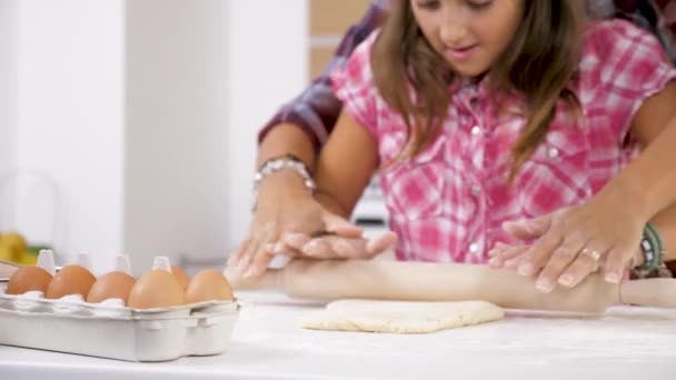 Мама помогает и учит догтер, как месить тесто — стоковое видео