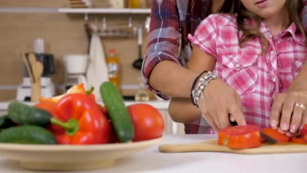 Η μητέρα βοηθά νέους doughter να κόψετε μια ντομάτα — Αρχείο Βίντεο
