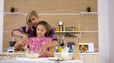 Güzel anne ve genç kızı birlikte mutfakta yemek