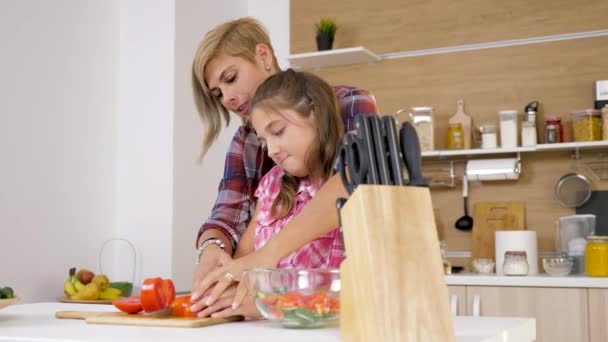 Mother helps young doughter to cut a tomato — Stock Video