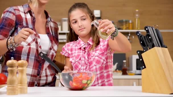 Молодая девушка наливает масло в салат — стоковое видео