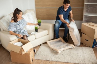 Genç çift yeni ev taşıma ve carboard kutuları açma