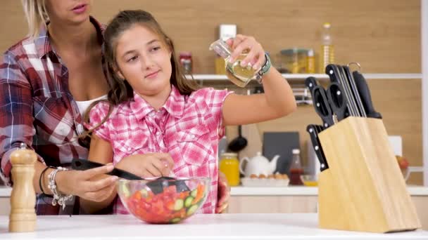 Chica joven vertiendo aceite en ensalada — Vídeos de Stock