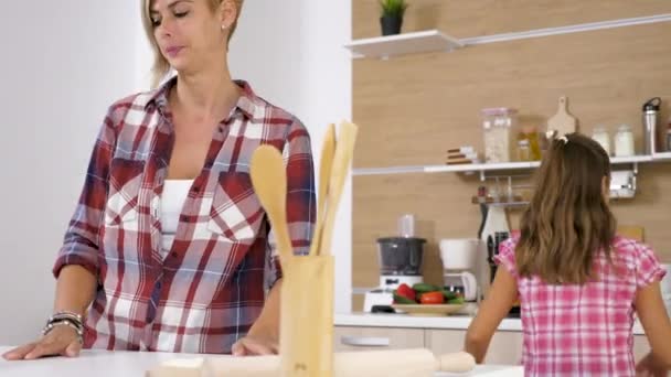 Слайдер Dolly 4K, снятый маленькой дочерью, помогает матери на кухне — стоковое видео