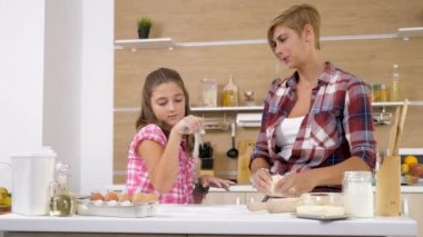 Dolly kaymak 4k görüntülerini anne ve genç kızı birlikte mutfakta yemek ve pişirme