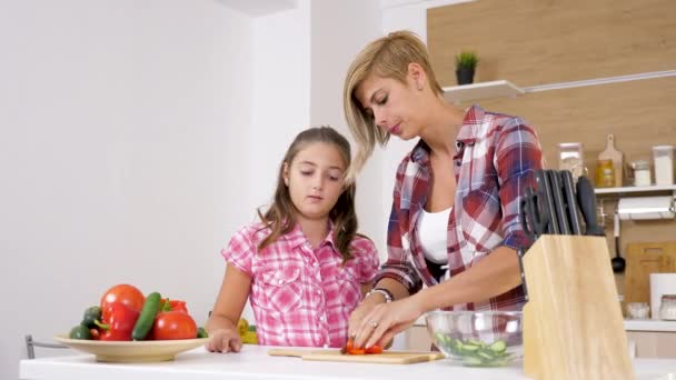 Мать и дочь на кухне режут сладкий красный пепер — стоковое видео