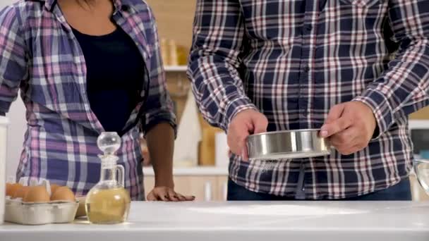 Par i köket sikta mjölet genom en sil — Stockvideo