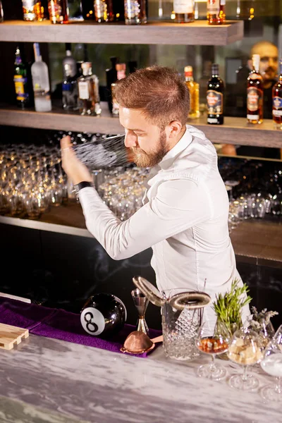 El camarero está haciendo cócteles en el mostrador del bar. — Foto de Stock