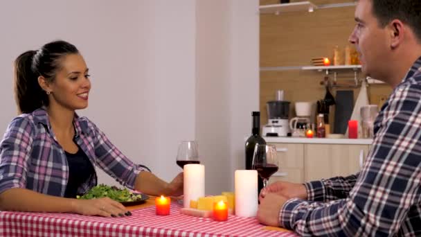 Vackert par i köket äter på levande ljus — Stockvideo