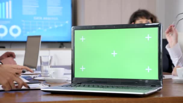 Υπολογιστή με πράσινη οθόνη chroma mock πάνω σε ένα τραπέζι στην αίθουσα συνεδριάσεων — Αρχείο Βίντεο