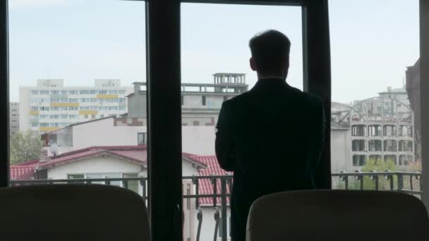 Zoom para fora filmagem homem de negócios olhando fora de sua janela do escritório — Vídeo de Stock