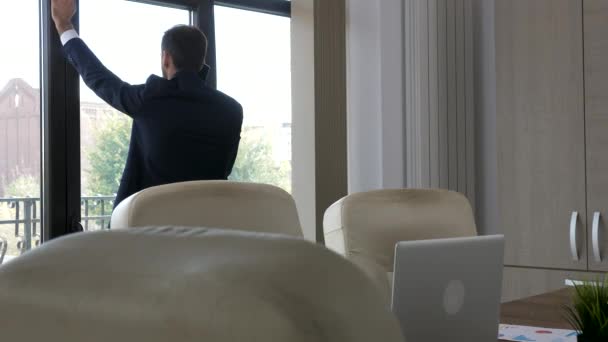Бизнесмен в своем офисе разговаривает по телефону — стоковое видео