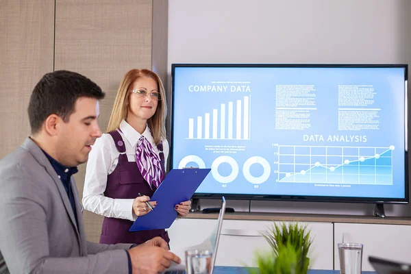 Empresarios y empresarios exitosos en la sala de conferencias analizando gráficos y diagramas en un televisor — Foto de Stock