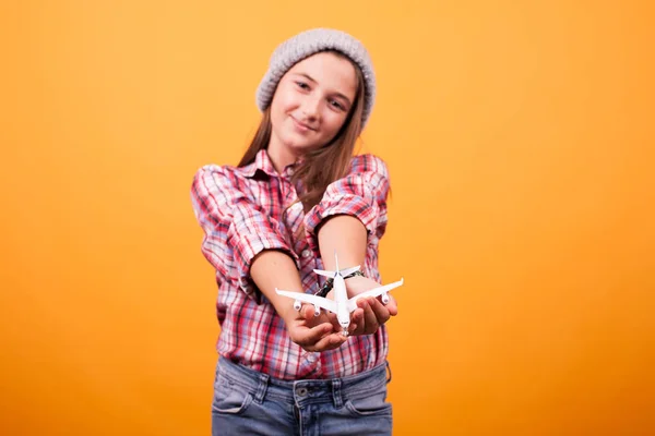 Menina brincadeira com avião de brinquedo em estúdio no fundo amarelo — Fotografia de Stock