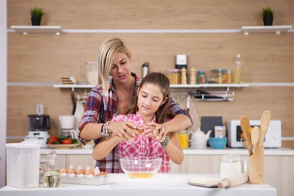 Mãe mostrando filha como cozinhar na cozinha doméstica — Fotografia de Stock