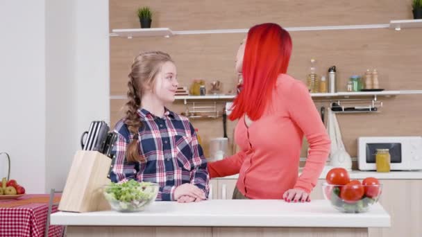 积极快乐的女孩帮助她的母亲在厨房 — 图库视频影像
