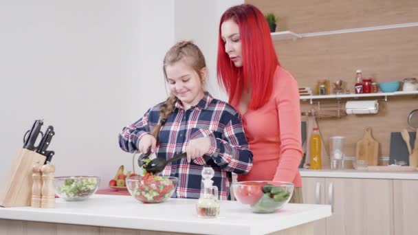 Мати і дочка готують вечерю разом на кухні — стокове відео
